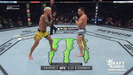 Chandler ủi lên phía trước, tận dụng lực bộc phá của đòn tay để ép Oliveira phải lùi bước. Oliveira cố gắng tìm kiếm Collar Tie nhưng không thành công, bị đấm choáng nhưng bắt được thời điểm chính xác để bốc vật phản công.