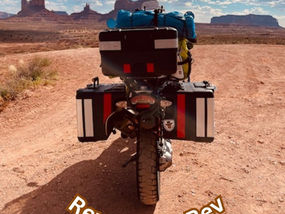 motorcycle, packed for a trip, driving across the desert