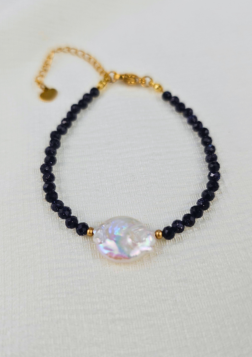 Detailaufnahme des Noctelle Armbands mit funkelndem blauem Sandstein, schimmernder Barock-Süsswasserperlen