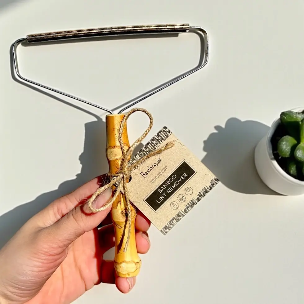 Thumbnail: Hand holding a "Bamboozle BAMBOO LINT REMOVER" with bamboo handle.