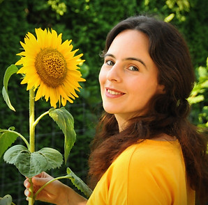 Portraitfoto der Autorin Felicitas Knaupp in Natur mit Sonnenblume in der Hand