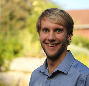Portraitfoto des Musikers Daniel Blechschmidt vor einem natürlichen Hintergrund