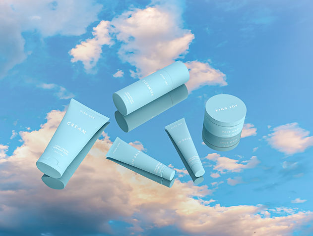 Photo of blue minimalist cosmetics packaging laid on a mirror that shows a reflection of a blue sky with white clouds