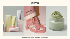 Cosmetic tubes and jars in pastel colors labeled "WHIPPED." Pink cream being dispensed. Minimalist design