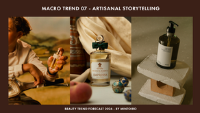Perfume bottles with earthy and elegant designs are showcased, flanked by a hand holding a spray and a bottle on textured blocks. Mood is artisanal.