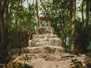 Stone structure representing an aluxes house nestled in the lush greenery of the Lunita Jungle Retreat Center near Cancun, Mexico.