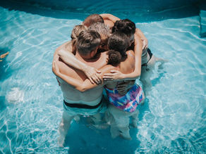 Participants share a heartwarming group embrace during a poolside ceremony at the Lunita Jungle Retreat's holistic wellness event in Mexico.