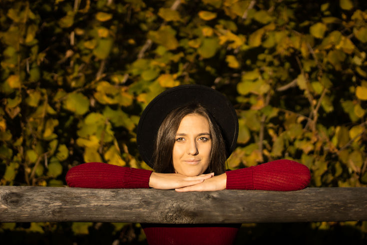una ragazza con una cappello nero e la maglia bordeaux.