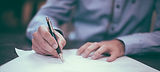 Person signing document with pen