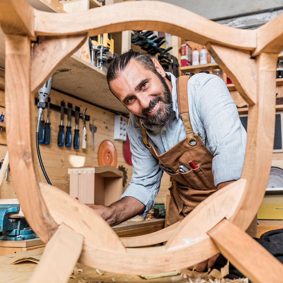 Smiling carpenter, wood frame, and tools in workshop. Carpentry & Woodwork in background.