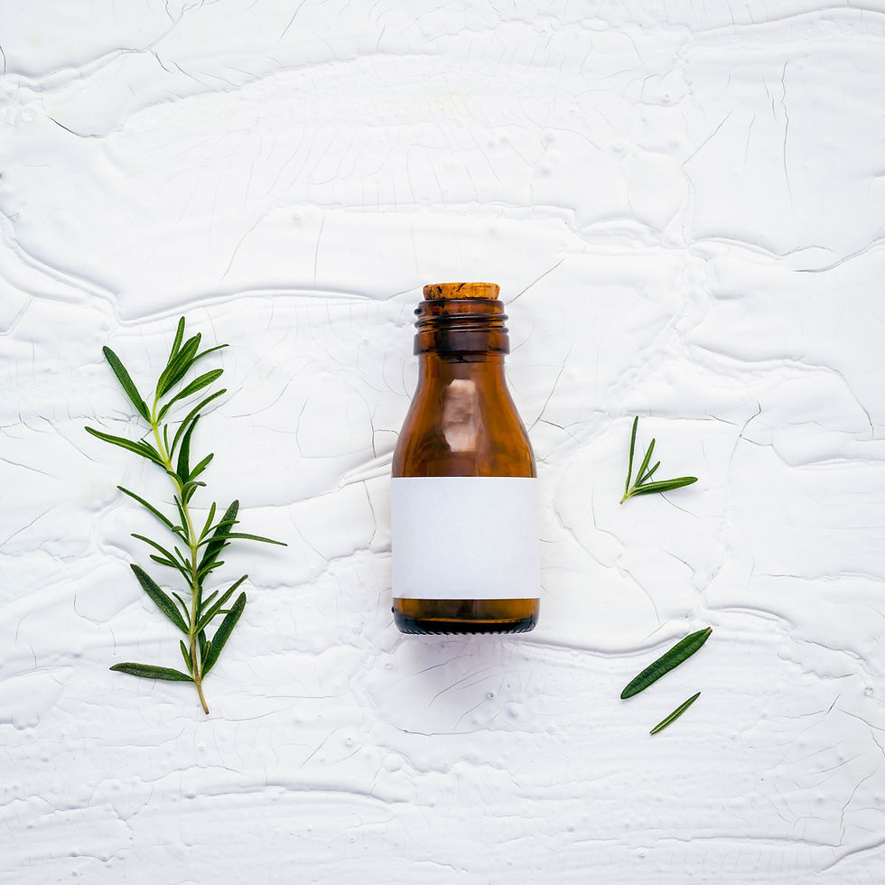 Brown bottle with blank label and rosemary sprigs on white background.