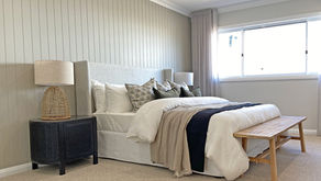 the feature wall and bed of a master bedroom