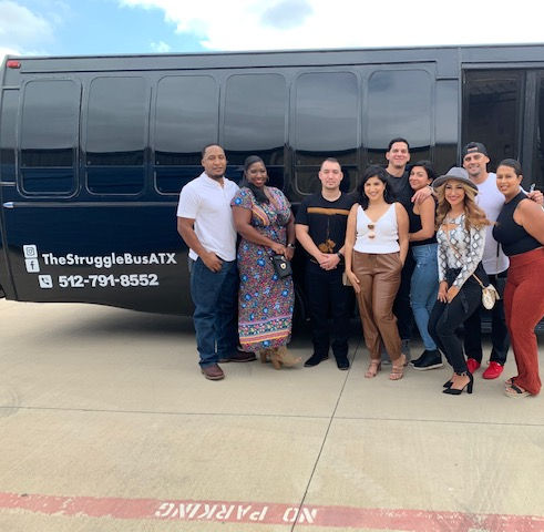 people posing in front of the Struggle Bus in Austin, Texas