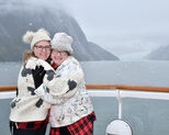 A family hugging in front of a Glacier in Alaska