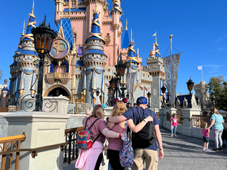 a family stands facing Cinderella Castle at Walt Disney World Resort