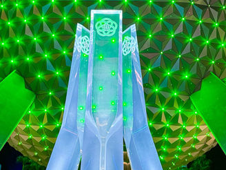 Spaceship Earth lit up green at night.