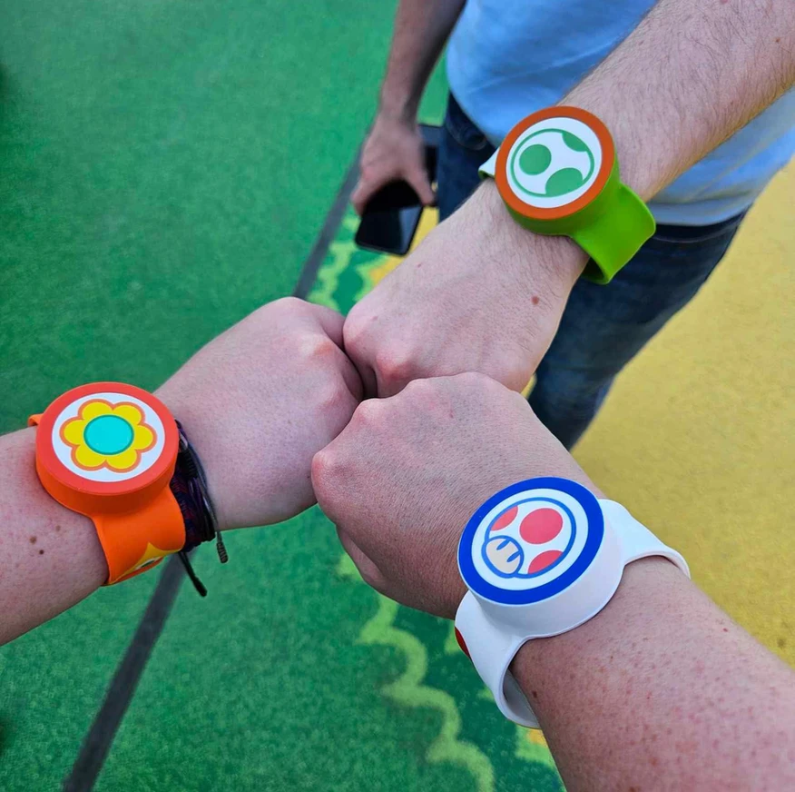 Three people's fist bumping with Power Up Bands at Epic Universe