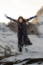 A woman poses like a flying bird in the Alps