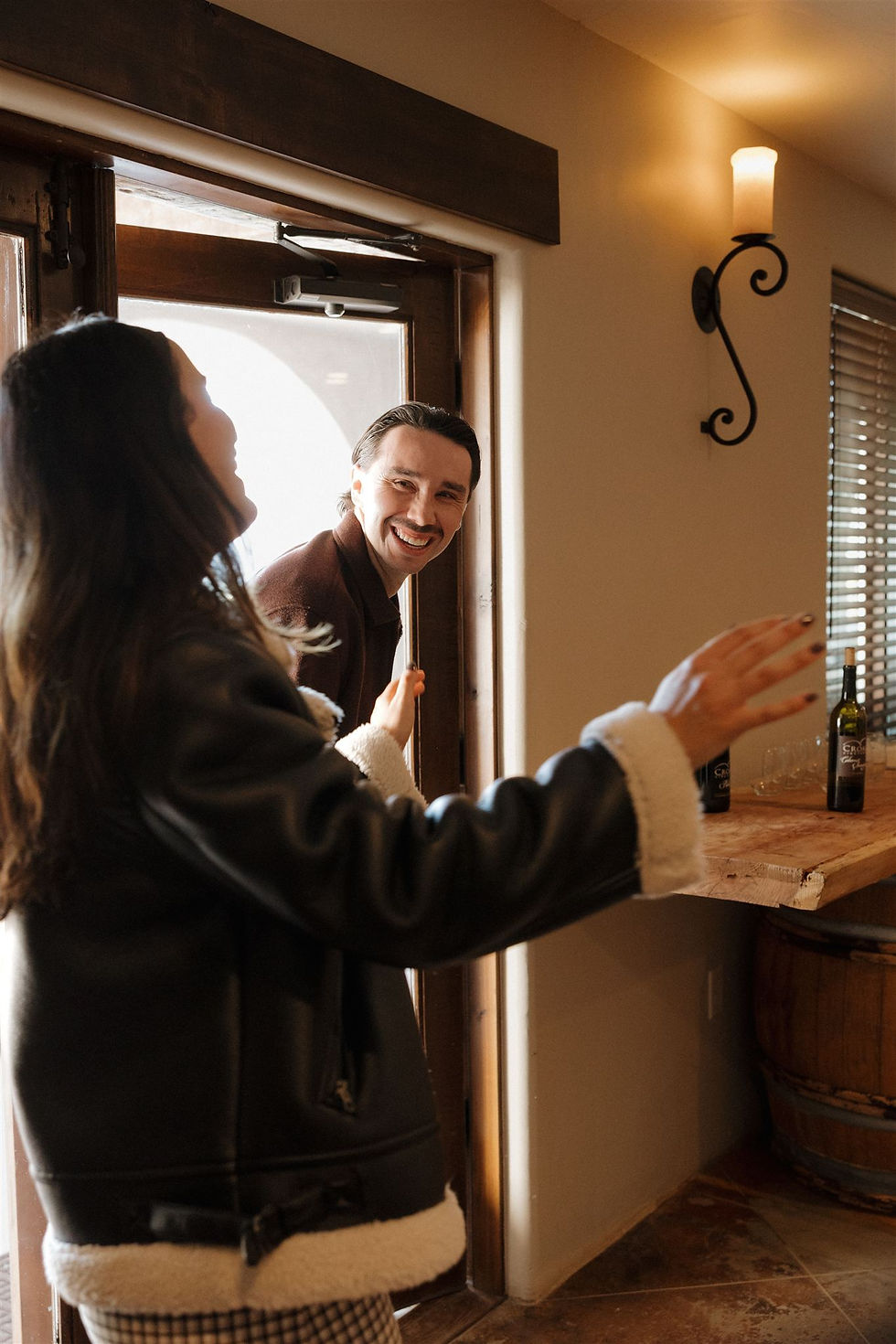 Couple entering barrel room to surprise engagement celebration