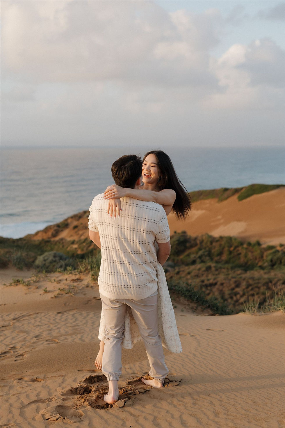 Romantic embrace overlooking Pacific Ocean cliffs