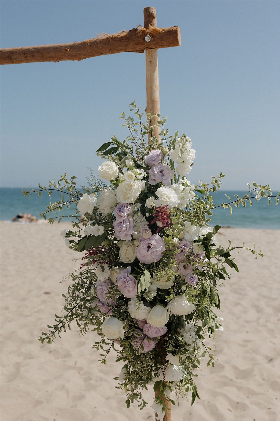White and lavender florals by Alpha Floral at Santa Barbara Beach Wedding ceremony