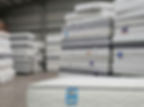 Stacked mattresses awaiting take-back collection in a warehouse