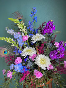 Fresh flowers combined with peacock feathers.