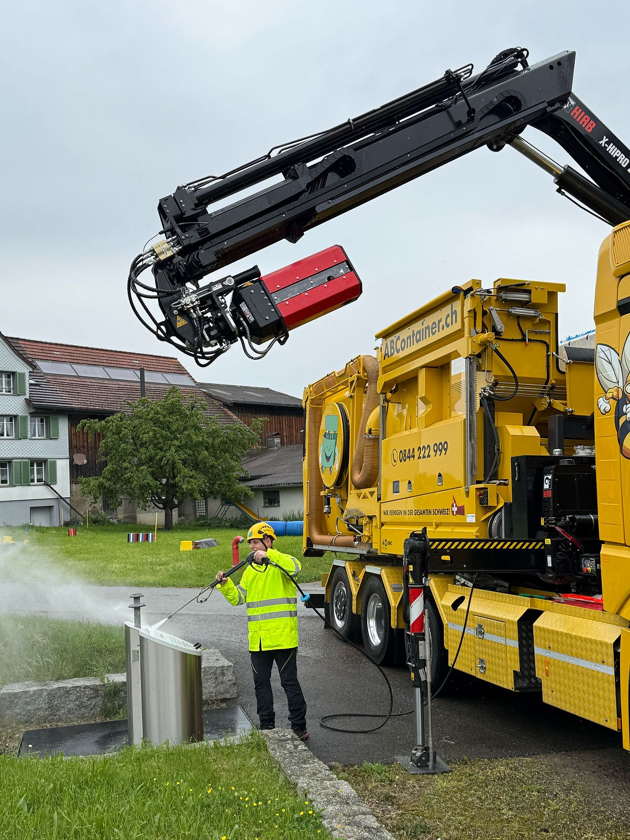 Mitarbeiter von ABContainer.ch reinigt Unterflurcontainer mit Hochdrucksystem vor Ort