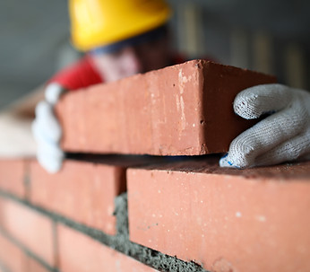 close-up-professional-construction-worker-laying-bricks-industrial-site-builder-protective
