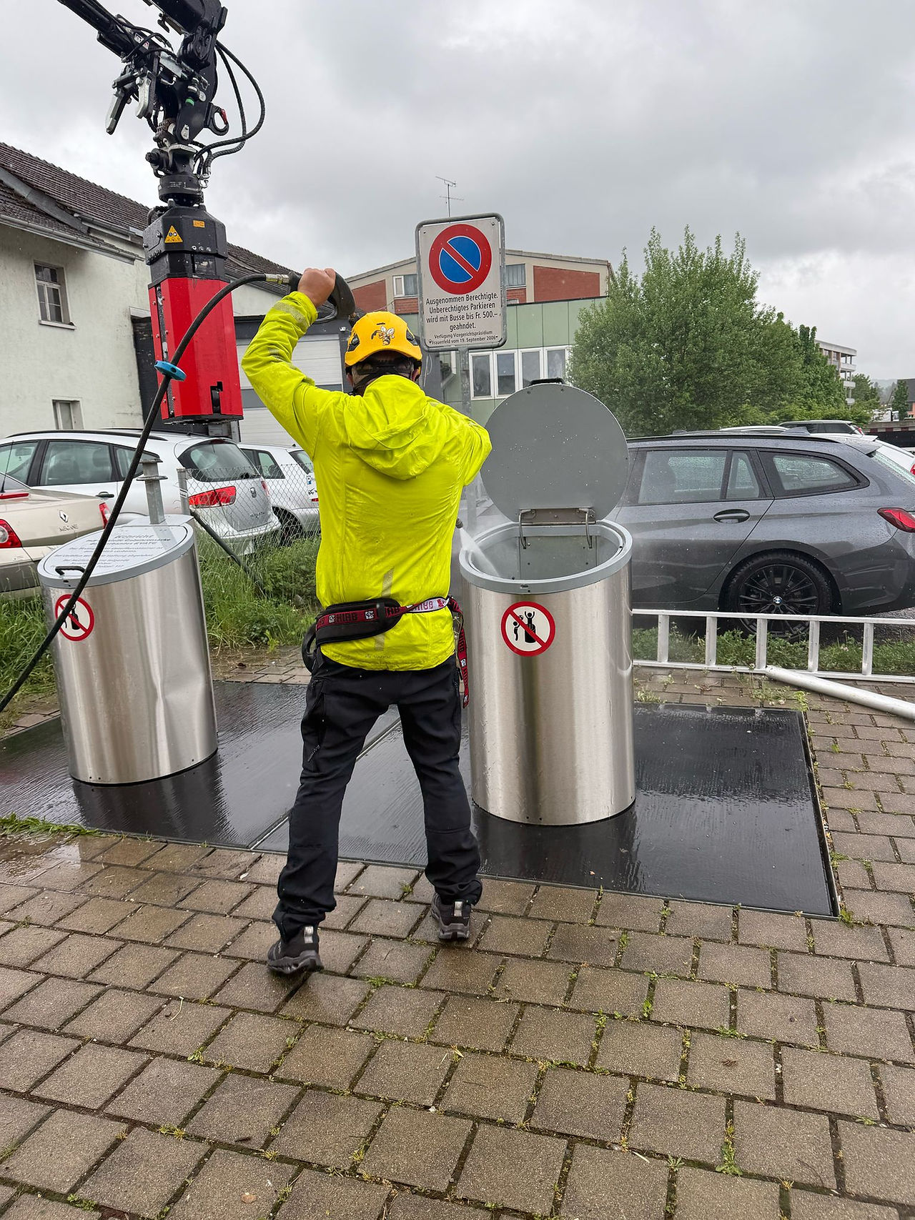Mitarbeiter von ABContainer.ch reinigt Unterflurcontainer mit Hochdrucksystem vor Ort