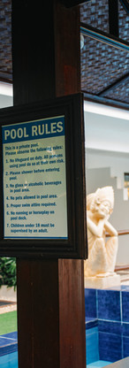 Pool rules sign with statues