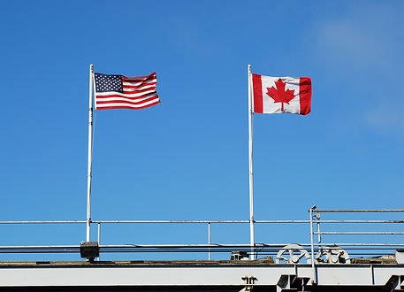 Flags flying at a US and Canadian border