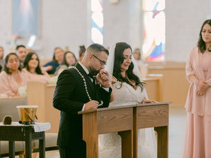 Groom tenderly kissing bride's hand during their wedding ceremony at St. Stephen Church in El Paso, captured by Photo by Jess