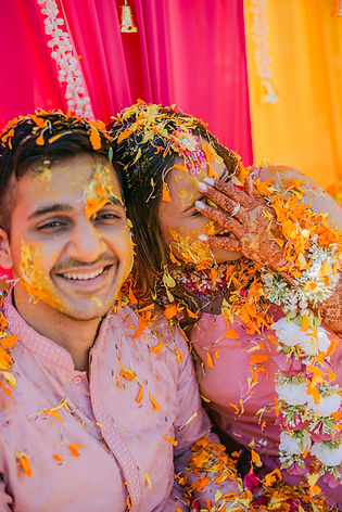 Vibrant Haldi ceremony celebration with bride and groom covered in turmeric paste, captured by El Paso wedding photographer Photo by Jess.