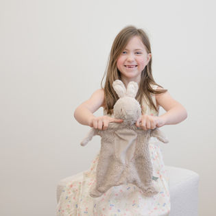 Young girl proudly showing off her beloved bunny during a Lovey & Me lifestyle photography session