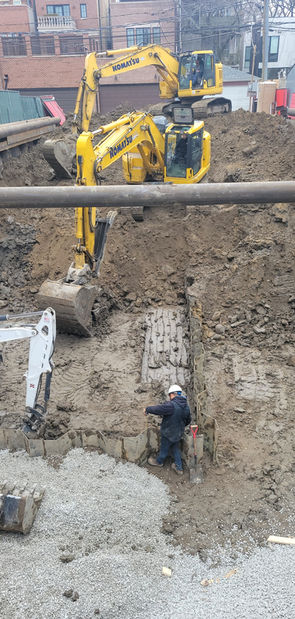 Two excavators can be seen on screen with another excavator just off screen as one of Brophy Excavator's specialists implement shoring.