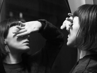 Kvinde dækker sine øjne, for ikke at se sit eget spejlbillede