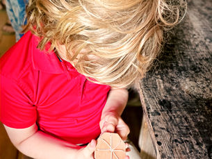 A camper learns the art of cord making using a traditional cord-making jig.