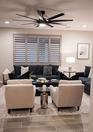 living room with navy couch and ivory accent chairs with chrome side table