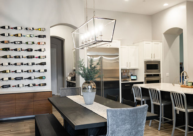 dining room with black dining table, chrome chandelier and wine display wall