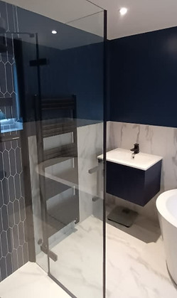 Modern bathroom with walk in shower, marble floors, sink and bathtub