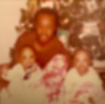 A cherished holiday memory: our father watches over us as my twin sister and I joyfully unwrap gifts in front of the twinkling Christmas tree.