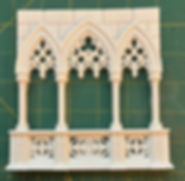 White gothic architectural model balcony with intricate arches, columns, and tracery.