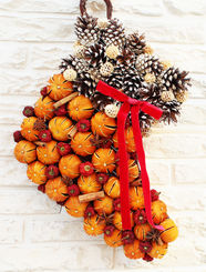 Experience a festive touch with our Christmas Stocking Wreath, meticulously crafted on a sturdy wooden base. This unique ornament features an enchanting blend of cones, dried mandarins, cinnamon sticks, and dried chillies, all scented with our signature 'Christmas in a Bottle' oil for an unforgettable Christmas aroma. Perfect for those seeking a distinctive Christmas decoration, this wreath promises to bring the warmth and essence of the season to your home.