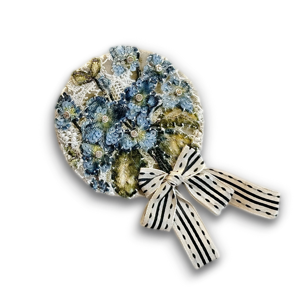 Cover image for the beginner-level course ‘Embroidered Brooch - Project “Steal Like an Artist” Episode 3,’ showcasing a circular hand-embroidered brooch with blue floral motifs, delicate beading, and an elegant striped ribbon accent.
