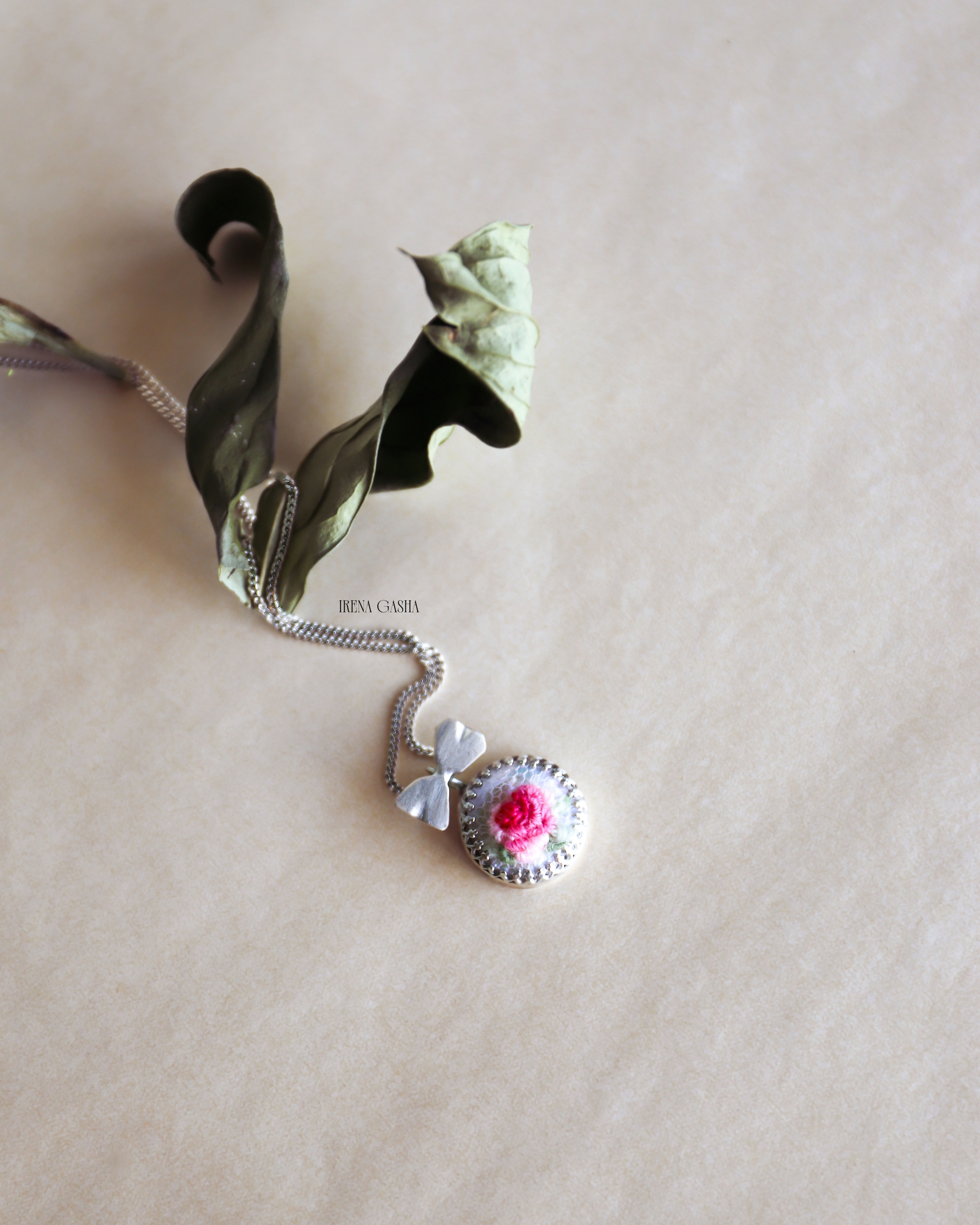 My Odd Pearls Miniature No. 01 "Rose" pendant, a hand-embroidered pink rose in wool thread on a pearl in a silver setting wit