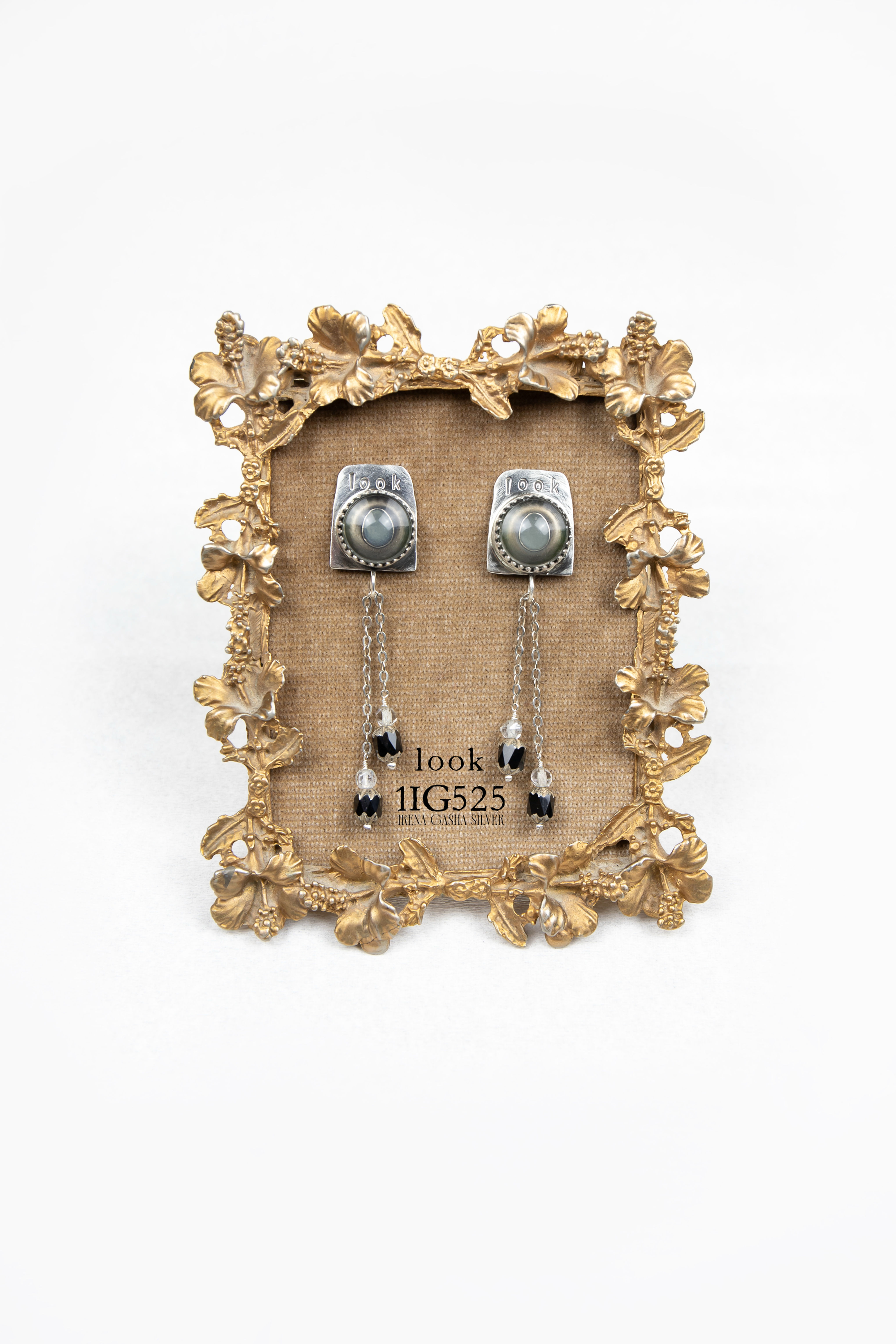 Sterling silver earrings titled “Look,” featuring round vintage glass eye cabochons set into textured square-style studs engr