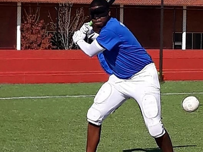 a blindfolded beep ball player swinging at the ball
