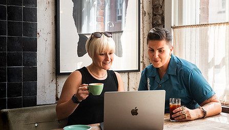 Eloise Rees from Squeeze the Lemon Studios chatting with a client over coffee about a video project.