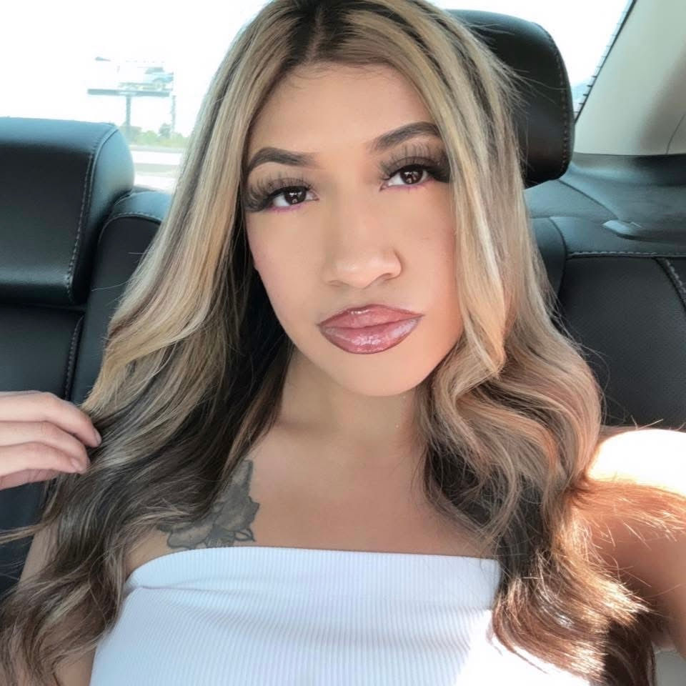 Woman with blonde and brown wavy hair in a car